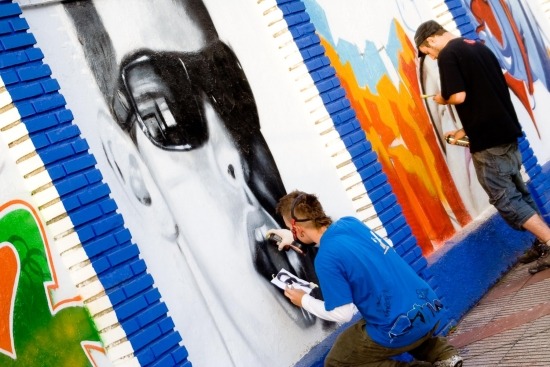 Dos jóvenes pintando un grafiti durante la FEMEX_1800x1200_0.preview